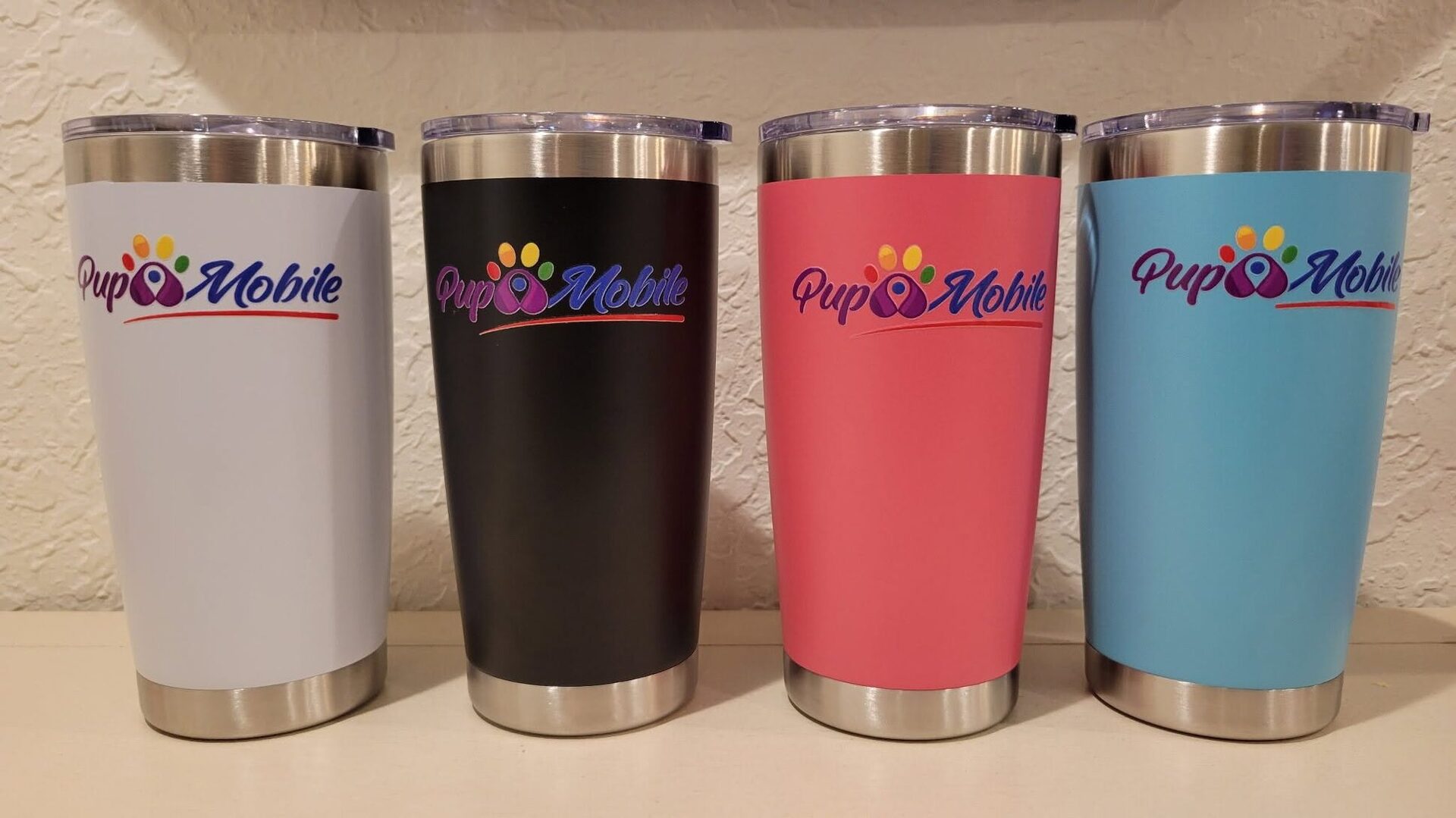 Four Pup Mobile tumblers in white, black, coral and blue