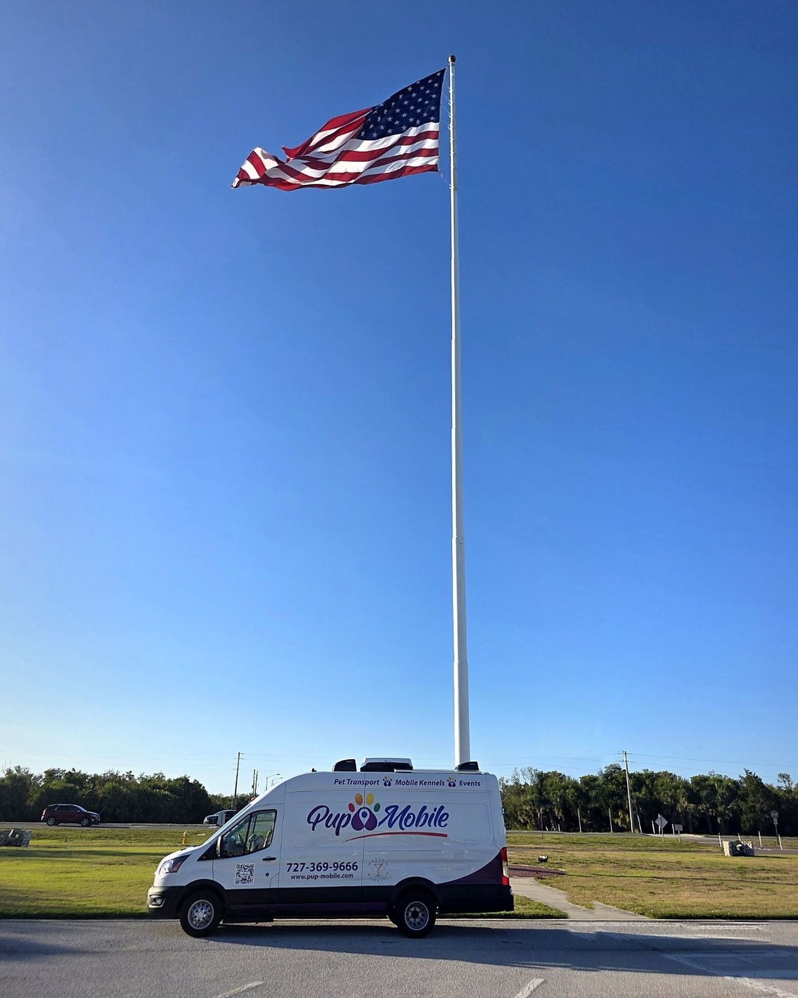 The Pup Mobile van beneath an American flag