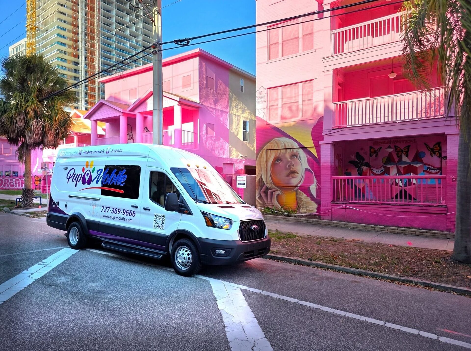 The Pup Mobile van in front of hot-pink mural buildings in St. Pete
