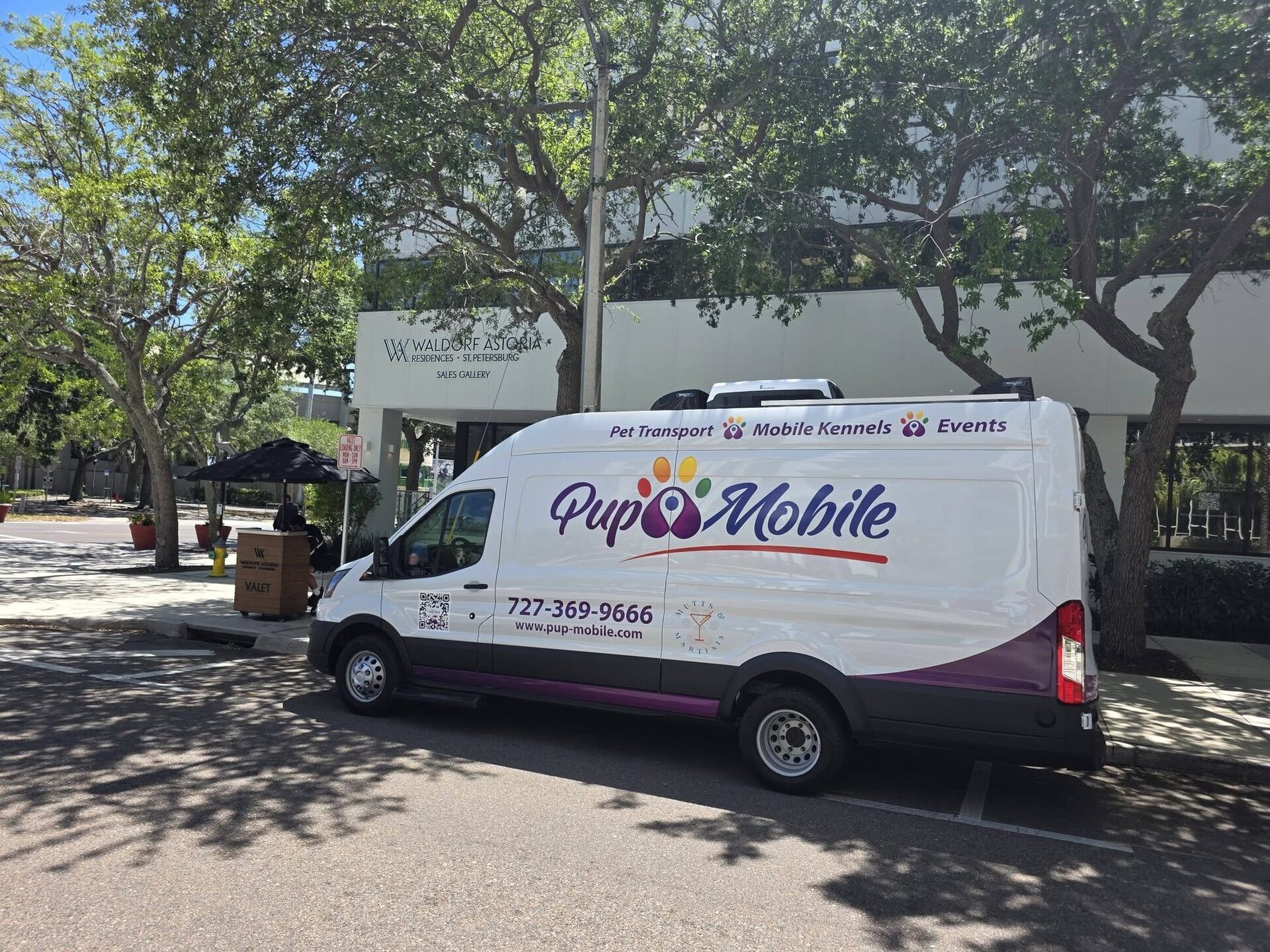 The Pup Mobile van parked under shade trees